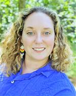 Lisa Davey wearing a blue shirt and colorful earrings